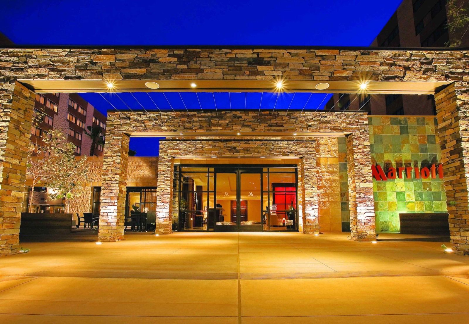 Stone grand entrance of the hotel glowing at dusk